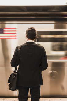 Junger Geschäftsmann wartet am Bahnsteig einer U-Bahn-Station - UUF09001