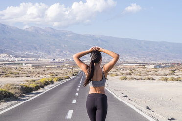 Young female athlete looking at road ahead - SIPF01021