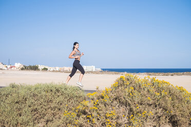 Junge Frau läuft am Strand - SIPF01027