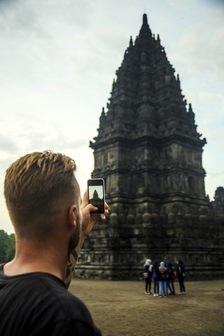 Indonesien, Java, Tourist beim Fotografieren des Prambanan-Tempels, lizenzfreies Stockfoto