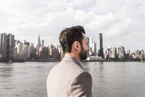 USA, New York City, Mann am East River vor der Skyline von Manhattan, lizenzfreies Stockfoto
