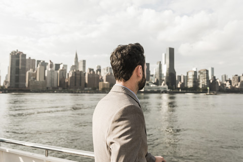 USA, New York City, back view of man at East River looking on Manhattan stock photo