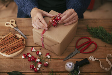 Frauenhände beim Verzieren von Weihnachtsgeschenken - RTBF00492