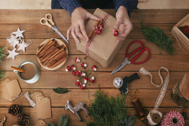 Frauenhände beim Verzieren von Weihnachtsgeschenken - RTBF00493