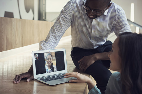 Geschäftsleute halten eine Videokonferenz auf einem Laptop ab, lizenzfreies Stockfoto