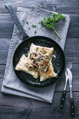 Vegetarische schwäbische Taschen mit Röstzwiebeln in der Pfanne, lizenzfreies Stockfoto