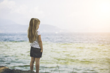 Italy, Lake Garda, girl standing at lakeshore - SBOF00256