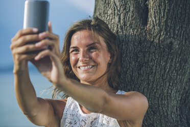 Young woman taking a selfie at a tree - SBOF00270