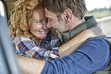 Happy couple hugging in car - FMKF03173