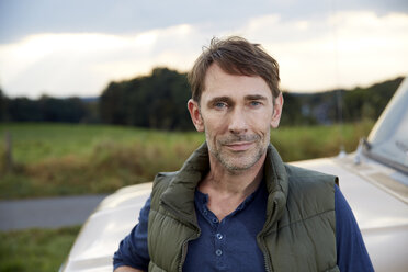 Portrait of man at pick up truck - FMKF03178