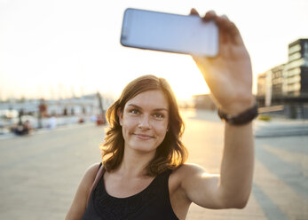 Deutschland, Junge Frau in Hamburg macht Selfie mit ihrem Smartphone - WHF00006