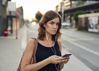 Deutschland, Junge Frau mit Smartphone auf Erkundungstour in Hamburg - WHF00013