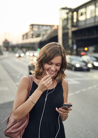 Germany, Young woman in Hamburg using smart phone stock photo