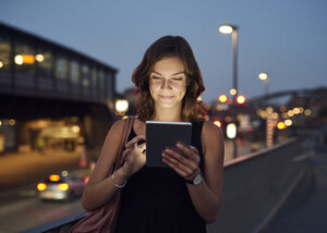 Deutschland, Hamburg, Junge Frau auf der Straße mit digitalem Tablet - WHF00018