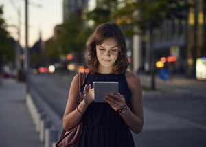 Deutschland, Hamburg, Junge Frau auf der Straße mit digitalem Tablet - WHF00035
