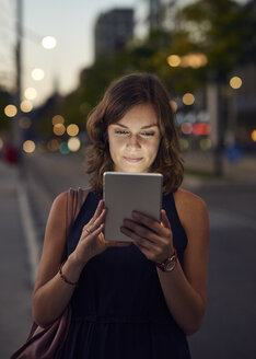 Deutschland, Hamburg, Junge Frau auf der Straße mit digitalem Tablet - WHF00036