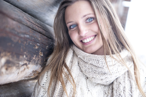 Porträt einer lächelnden blonden Frau in Strickwaren im Winter, lizenzfreies Stockfoto