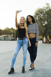 Two young women taking a selfie on square - KKAF00015