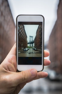 Mann macht ein Foto mit Smartphone in Dumbo, Brooklyn - GIOF01589