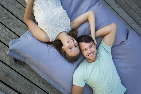 Young couple in love relaxing together on beanbag - JTLF00124