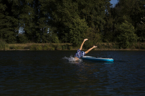 Boy jumping from SUP Board into water - JTLF00134