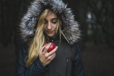 Junge Frau mit rotem Apfel und Kapuzenjacke - KKAF00064