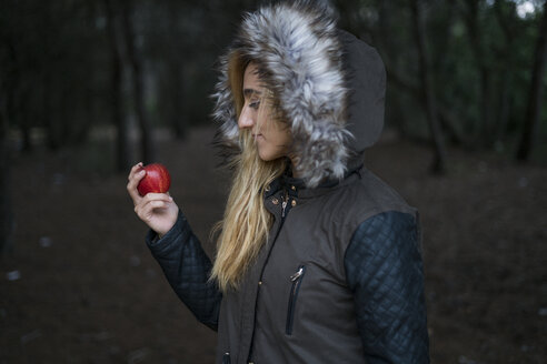 Junge Frau mit rotem Apfel und Kapuzenjacke - KKAF00065