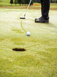 Golfer on golf course with dew, partial view - LAF01774