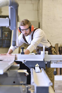 Schreiner bei der Arbeit mit einer Säge in seiner Werkstatt - LYF00659