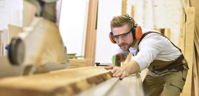 Carpenter using sawing machine in his workshop - LYF00660