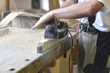 Schreiner bei der Arbeit mit dem Hobel in der Werkstatt - LYF00671