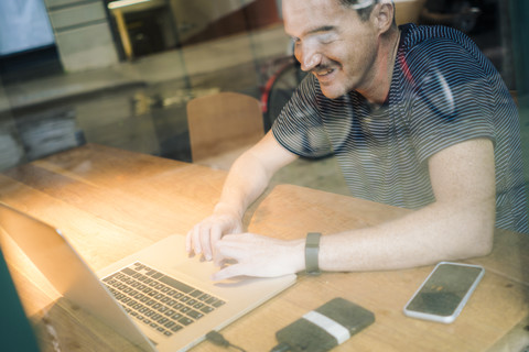 Man using laptop at desk stock photo