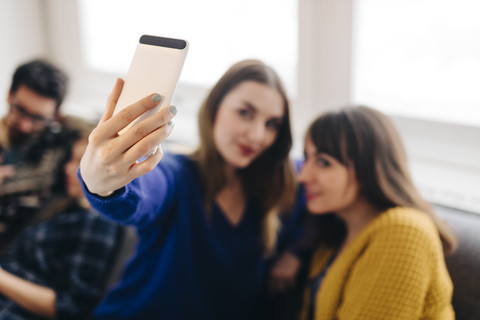 Young woman taking a selfie with a smartphone stock photo