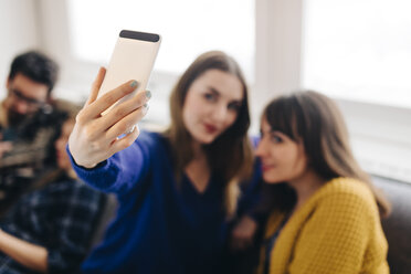 Junge Frau macht ein Selfie mit einem Smartphone - LCUF00079