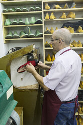 Schuhmacher mit einer Maschine in seiner Werkstatt - ABZF01474