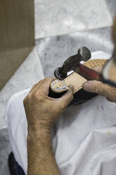 Shoemaker nailing nails in the heel of a shoe - ABZF01478