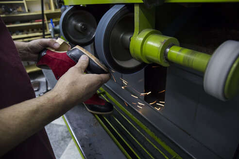 Schuhmacher mit einer Maschine in seiner Werkstatt - ABZF01481