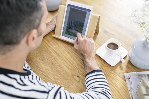 Mann benutzt Tablet auf Tisch, lizenzfreies Stockfoto