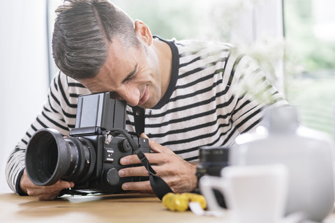 Mann zu Hause überprüft Kamera, lizenzfreies Stockfoto
