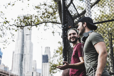 Two smiling friends with basketball outdoors - UUF09142