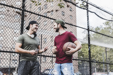 Zwei lächelnde Freunde beim Basketball im Freien - UUF09144