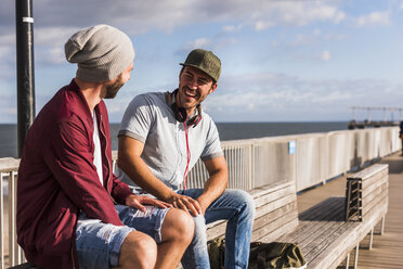 USA, New York City, two friends sitting on bridge on Coney Island - UUF09172