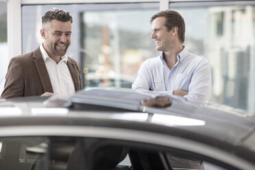 Car showing car to happy customer at car dealership - ZEF11532