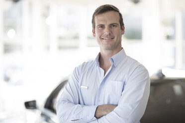 Portrait of confident car dealer in showroom - ZEF11538