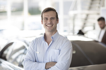 Portrait of smiling car dealer in showroom - ZEF11539