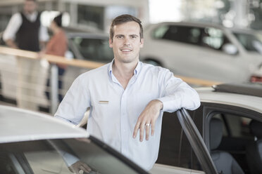 Portrait of confident car dealer in showroom - ZEF11564