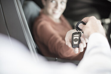 Autohändler übergibt Schlüssel an Frau im Autohaus - ZEF11569