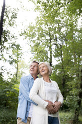 Glückliches älteres Paar, das sich im Wald entspannt - HAPF01049