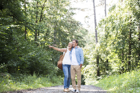 Senior couple standing on forest track watching something stock photo