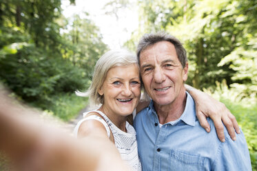 Glückliches Seniorenpaar macht Selfie im Wald - HAPF01069
